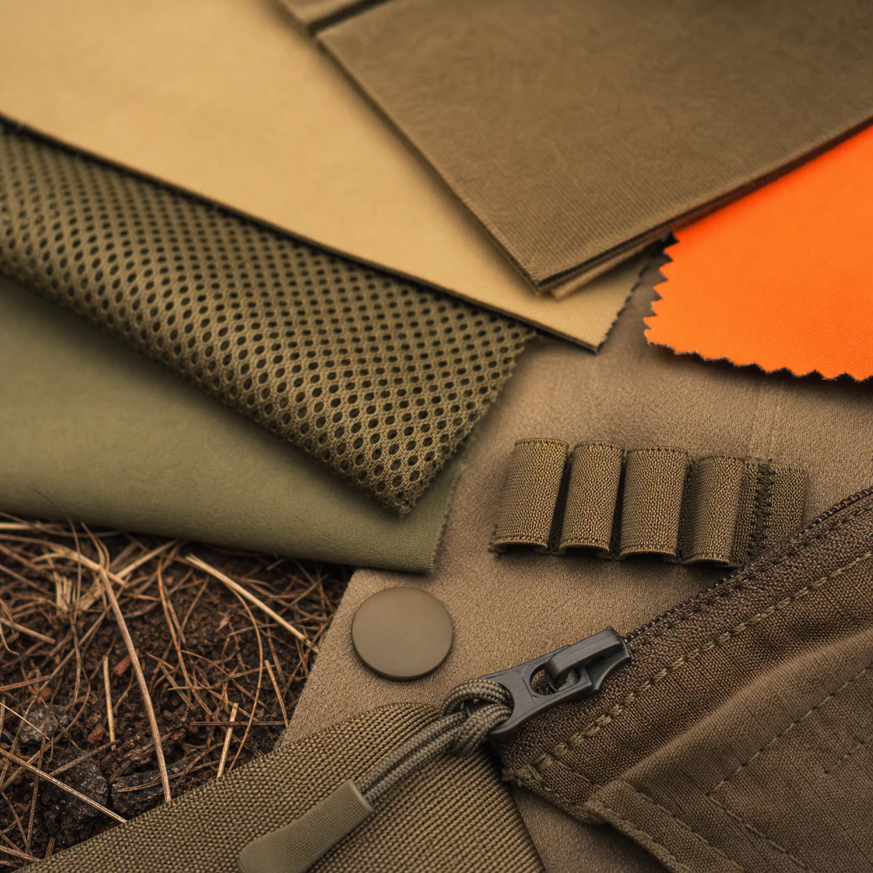 Upland hunting fabric, mesh, blaze panel, zipper and shell-loop detail